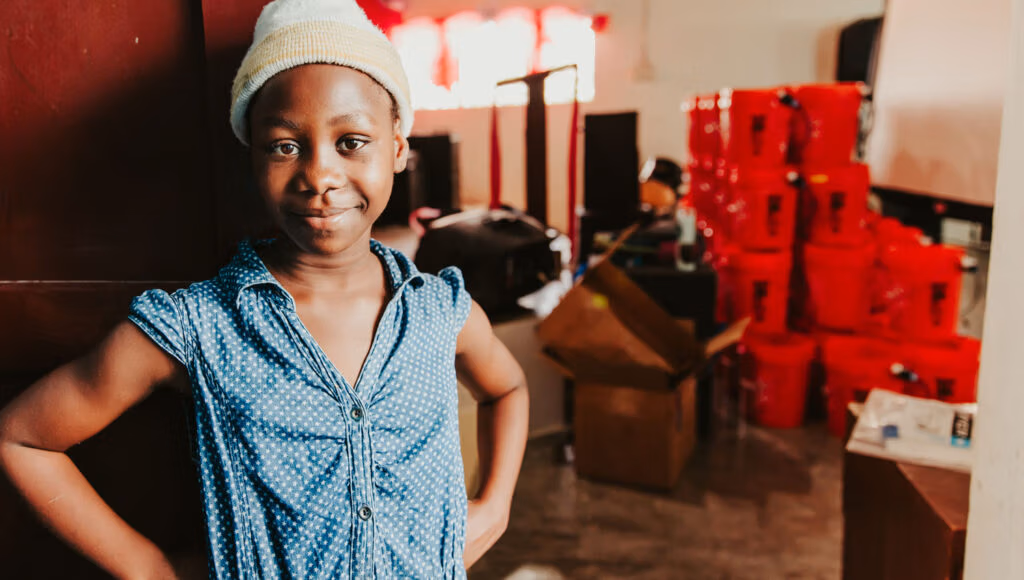 Young girl standing near water filter equipment