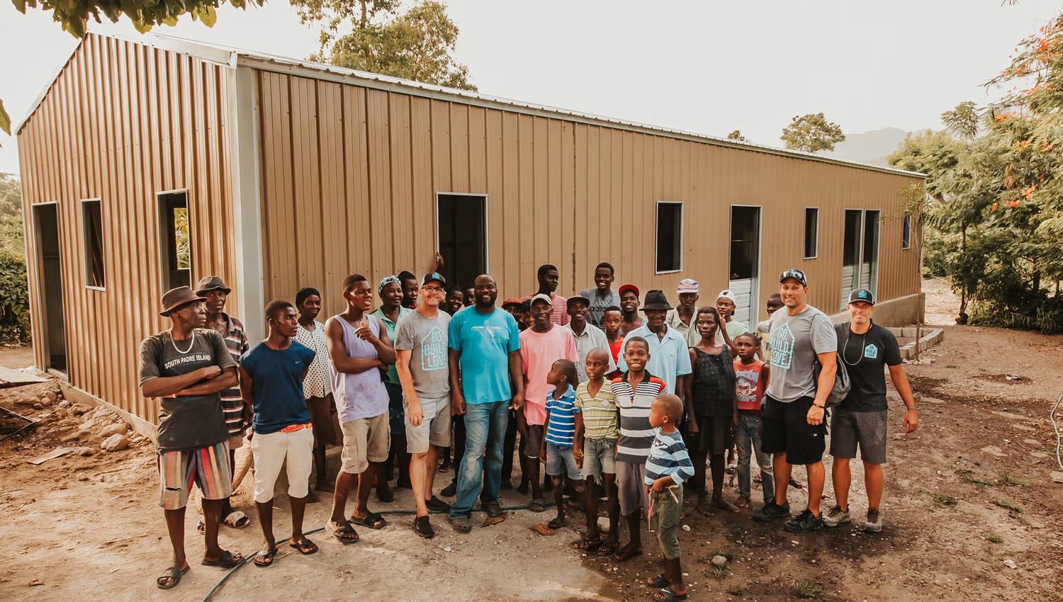 Community members and GBL volunteers gathered outside a completed building