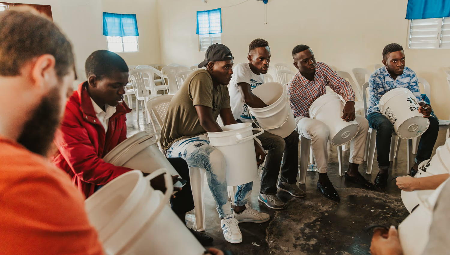 Group learning how to use clean water buckets and filters